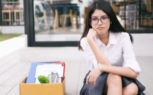 Smutna kobieta z rzeczami ze swojego biurka