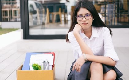 Smutna kobieta z rzeczami ze swojego biurka