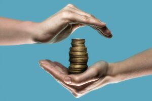 Dłoń trzymajaca stos monet